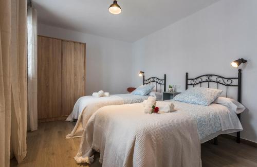 1 Schlafzimmer mit 2 Betten in Weiß und Blau in der Unterkunft Paco del Molino 2 in Grazalema