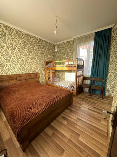 a bedroom with a bed and a crib at Holiday house Tbilisi in Tbilisi City