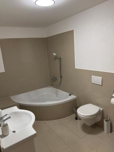 een badkamer met een bad, een toilet en een wastafel bij Elegantes City-Apartment im MG-Zentrum in Mönchengladbach