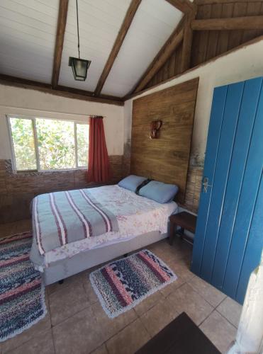 a bedroom with a bed and a blue door at Atelie Hospedagem in Palhoça