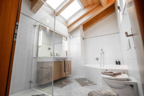 a bathroom with a toilet and a sink and a shower at Turuwang Penthouse by HomeFlow in Zermatt