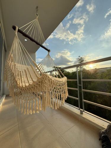 een hangmat op een balkon met uitzicht op de zonsondergang bij Apartamento con piscina y Aire Acondicionado en Anapoima centro in Anapoima