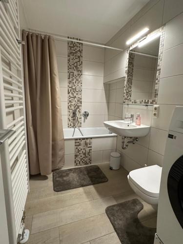 a bathroom with a sink and a tub and a toilet at Ferienwohnung Villa Fuchs in Dresden