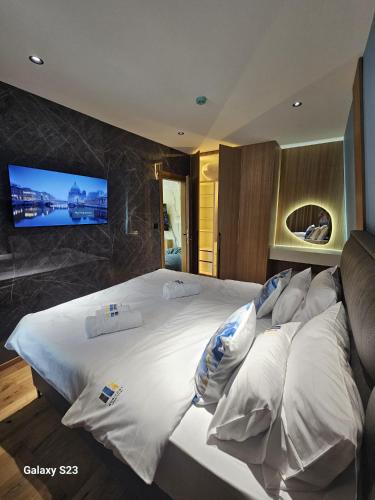 a bedroom with a large bed with a tv on the wall at Apartman Blue Sky in Jahorina