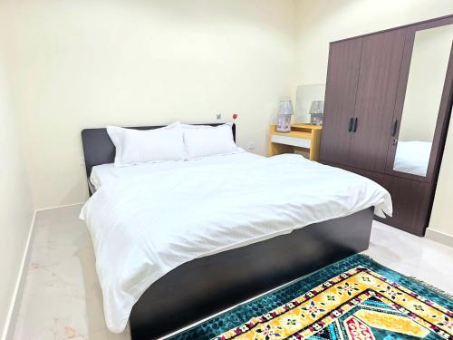 a bedroom with a bed with a mirror and a rug at RAK Corniche Stay Home in Ras al Khaimah