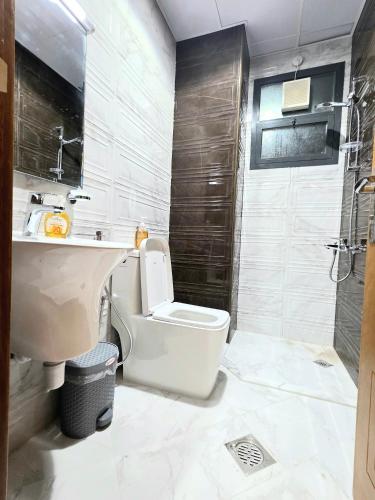 a bathroom with a toilet and a sink and a shower at RAK Corniche Stay Home in Ras al Khaimah
