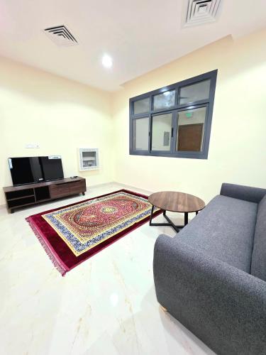 a living room with a couch and a table at RAK Corniche Stay Home in Ras al Khaimah