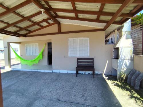 een terras met een houten dak en een stoel bij Kitnet em Arroio do Sal in Arroio do Sal