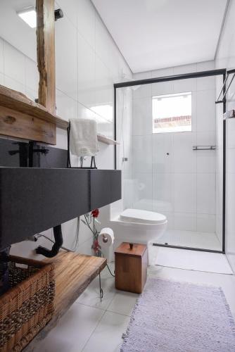 a bathroom with a shower and a white toilet at Casa Sunset in Urubici