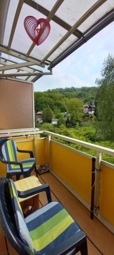 een balkon met twee stoelen, een schoolbord en een projector bij Apartment mit Herz in Sondershausen