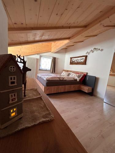 a bedroom with a bed in a room with wooden ceilings at Alpen Lodge Predazzo in Predazzo