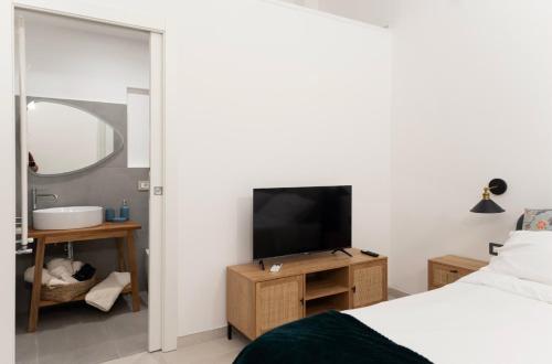 a bedroom with a bed and a tv and a mirror at Ada&niní in Galatina
