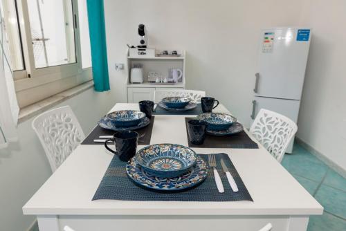 une table blanche recouverte de plaques bleues et blanches dans l'établissement Porta della costiera, à Vietri