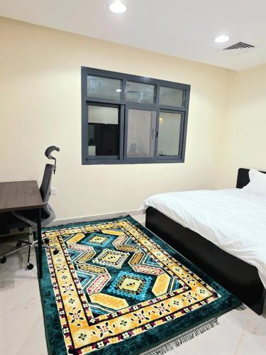 a bedroom with a bed and a rug on the floor at RAK Corniche Stay Home in Ras al Khaimah