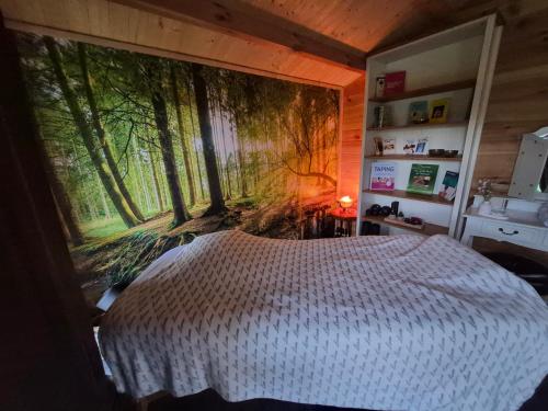 a bedroom with a large mural of trees on the wall at Ferienwohnung Thomée in Looft