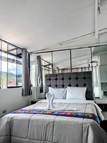 a bedroom with a large bed and a large window at HOSTAL La RASA in Cusco