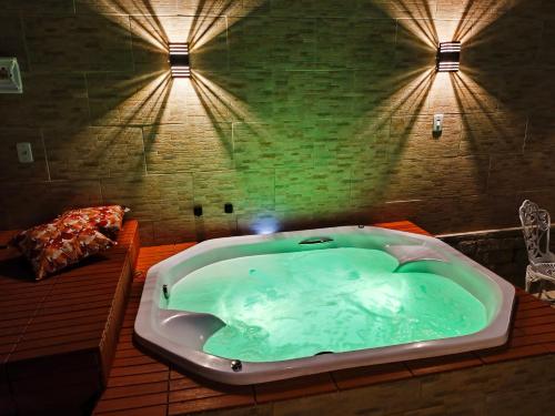 een groot bad in een kamer met 2 verlichting bij Flat e suítes com cozinha e churrasqueira in Conservatória