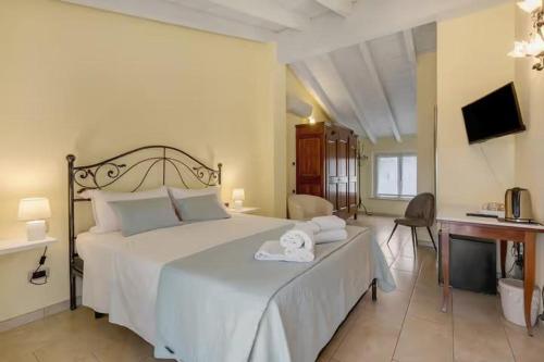 una camera da letto con un grande letto bianco con asciugamani sopra di Residenza Amé Peschiera del Garda a Peschiera del Garda