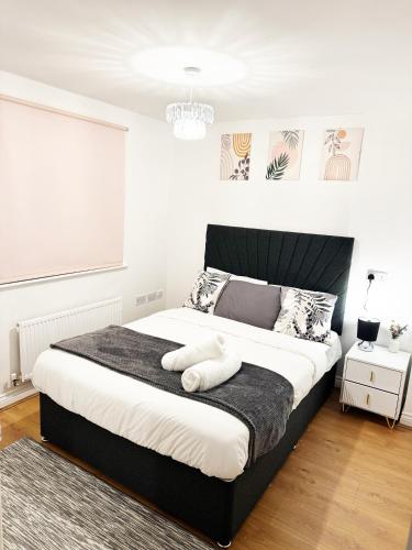a bedroom with a large bed with a black headboard at Stylish MK Flat in Milton Keynes