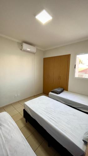 une chambre avec deux lits et une fenêtre dans l'établissement Residencial Ibis, à Bauru