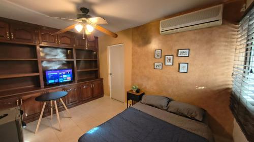 een woonkamer met een bank en een plafondventilator bij Santafe Minisuites in Hermosillo