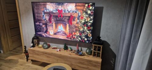 een kersthaard met een kerstboom aan de muur bij Słoneczna Dolina SPA Belle View in Szklarska Poręba