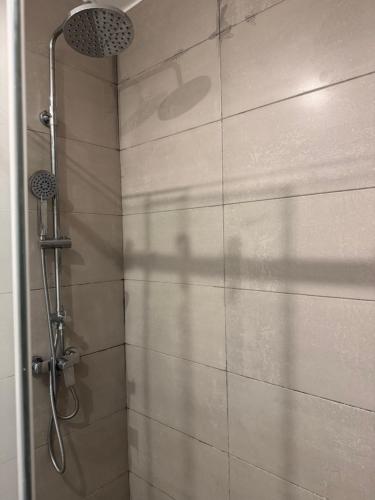een douche met een douchekop in een badkamer bij Nova by Devtraco plus in Accra