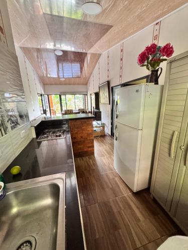 Una cocina con un refrigerador blanco y un fregadero. en Finca Villa Julia, en La Vega