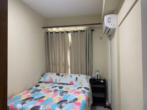 a bedroom with a bed with a colorful comforter at Porto Marina in Salvador