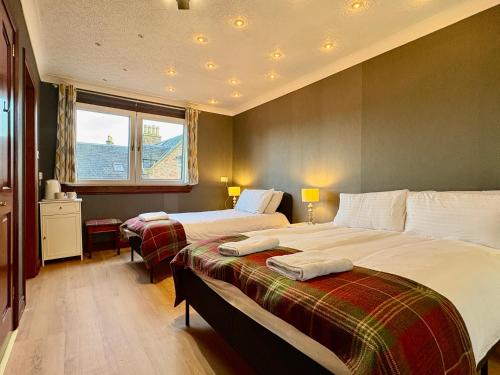 een hotelkamer met twee bedden en een raam bij Tanera in Inverness