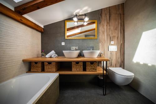a bathroom with two sinks and a tub at Villa Nika - Rustic Stone House with Heated Pool in Rasopasno