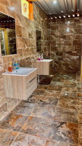 a stone bathroom with two sinks and a mirror at Wadi Rum Bedoun in Wadi Rum