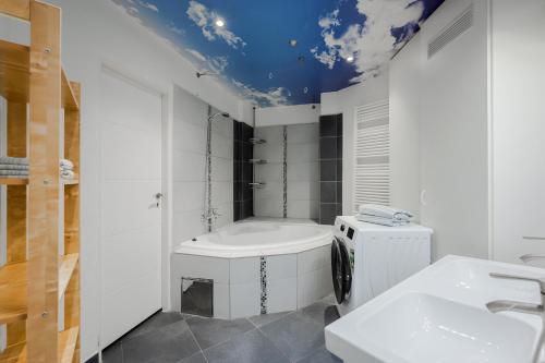 a bathroom with a bath tub and a sink at Old Town & Parking Assistance in Prague