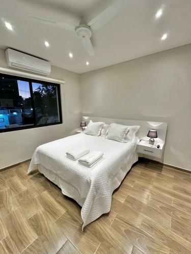 une chambre avec un lit avec des draps blancs et une fenêtre dans l'établissement Modern studio apartment in Asunción, à Asuncion