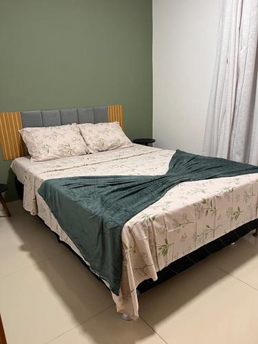 a bedroom with a bed with a gray headboard at Sossego Potiguar in Parnamirim