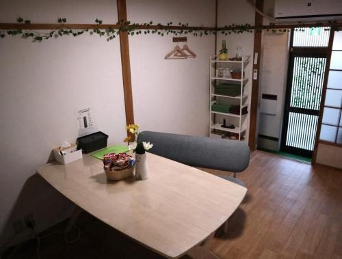 a living room with a table and a couch at Green House 大阪 in Osaka