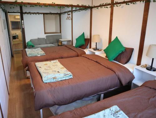 a bedroom with three beds and a couch at Green House 大阪 in Osaka