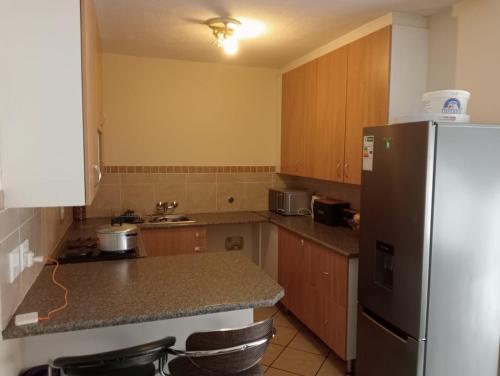 een keuken met een koelkast en een aanrechtblad bij Fairway Gardens in Pretoria