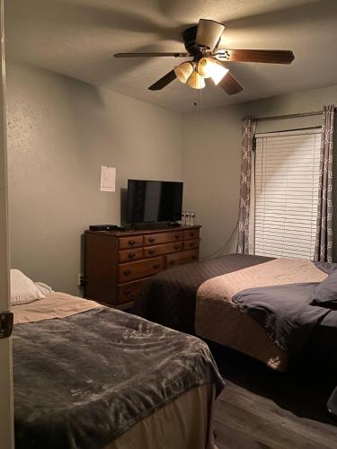 a bedroom with two beds and a ceiling fan at Home Away in Grand Prairie