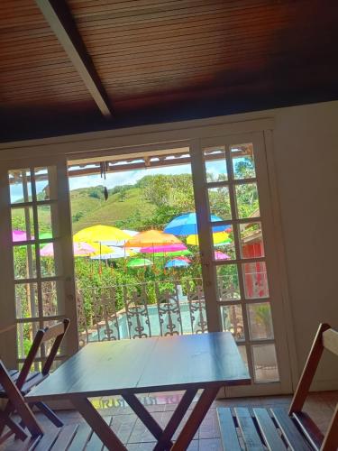 een tafel met stoelen en parasols voor een raam bij pousada talho da serra tempera in Valença