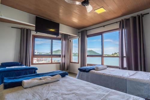 a bedroom with two beds and a large window at Hostel Chico Lessa in Vitória