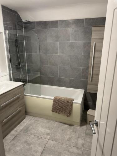 une salle de bain avec une douche, une baignoire et un lavabo dans l'établissement Rowe Terrace Workington, à Workington