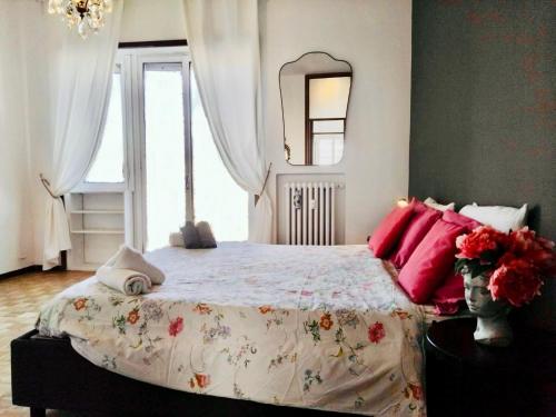 a bedroom with a large bed with red pillows at Charming Central Relais in Bergamo