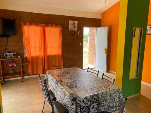 une salle à manger avec une table et un mur coloré dans l'établissement Lucero de Brochero, à Villa Cura Brochero