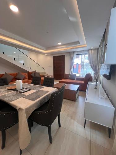 a dining room and living room with a table and chairs at DjossayaHomes in North Legon