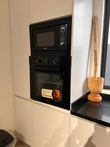un forno a microonde posizionato sopra una stufa di DjossayaHomes a North Legon