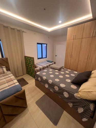 een slaapkamer met twee bedden en een stoel erin bij DjossayaHomes in North Legon