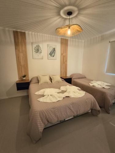 een slaapkamer met 2 bedden en een plafond bij Dunas de Arena in La Porteña