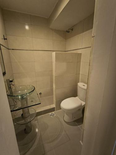 een badkamer met een toilet en een glazen wastafel bij Dunas de Arena in La Porteña