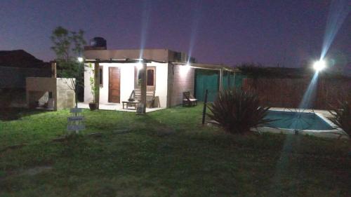 una piccola casa con una piscina nel cortile di notte di Complejo La Cabañita a San Rafael